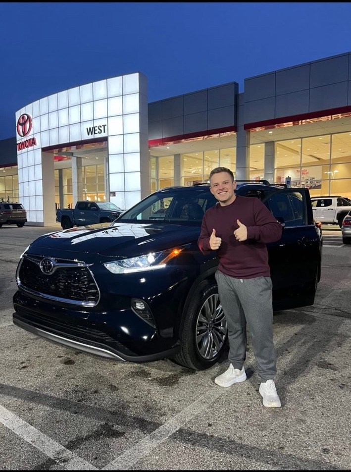 Customer celebrating beside a Toyota SUV